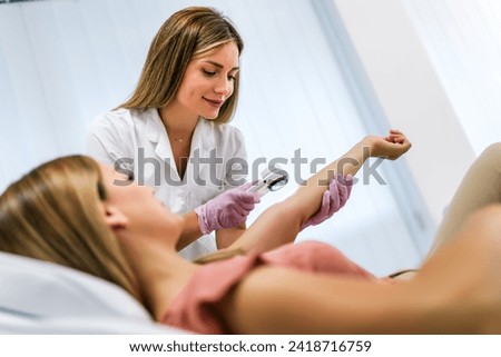 The dermatologist examines the moles or acne of the patient with a dermatoscope. Prevention of melanoma Royalty-Free Stock Photo #2418716759
