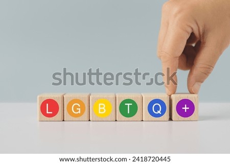 Concept of LGBTQ rights and law. pride month celebrate annual in June social of gay, lesbian, bisexual, transgender, human rights. Hand arranged wooden cube with text in multicolor circle 