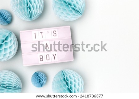 It's a boy. Lightbox with letters and tissue paper balls in a blue color. Baby shower concept with place for your design. 