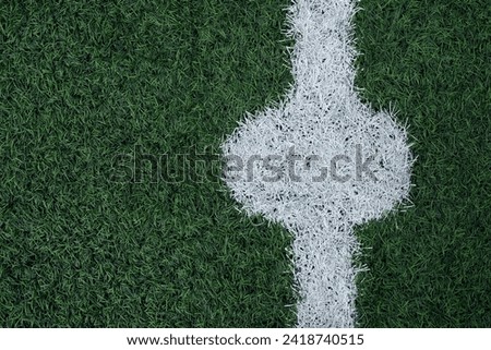 Fragment of Soccer field. Detailed shot of synthetic grass with white line. Artificial green grass, football field surface, top view. Design element, place for text.