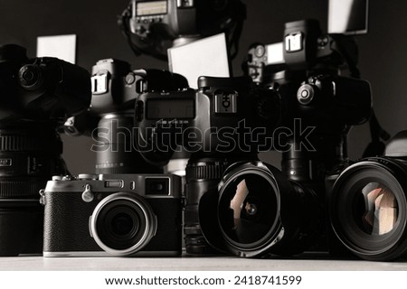 Modern cameras on white table, closeup. Professional photography equipment