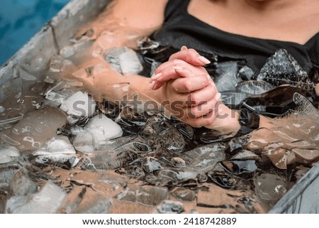 Body and hands of a girl or woman ice bathing in the cold water among ice cubes in a vintage bathtub. Wim Hof Method, cold therapy, breathing techniques, yoga and meditation Royalty-Free Stock Photo #2418742889