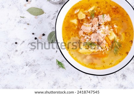 Fish soup with salmon, vegetables and rice in white bowl. Salmon soup. Top view, flat lay