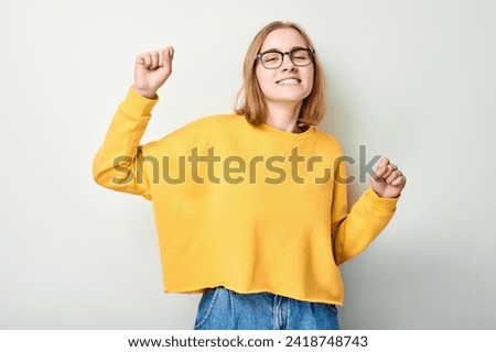 Portrait of smiling face girl clenching fists and rejoicing, celebrating victory isolated on white studio background, advertising banner
