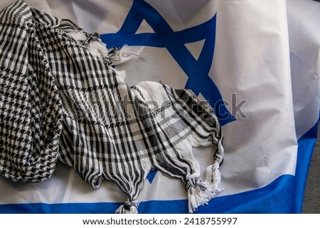 Israel flag and Palestinian scarf together lying on a rope to dry after washing or lying on a surface