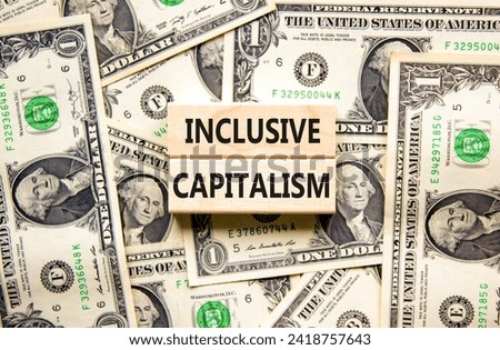 Inclusive capitalism symbol. Concept words Inclusive capitalism on beautiful wooden blocks. Dollar bills. Beautiful background from dollar bills. Business inclusive capitalism concept. Copy space.