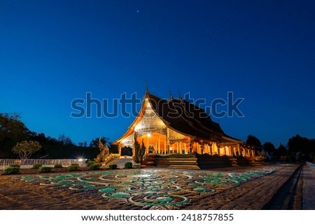 Amazing Temple Sirindhorn Wararam Phuproud in Ubon Ratchathani Province at twilight time,Thailand.Thai temple with grain and select white balance.Night sky effect for Long exposure