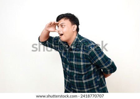 Young asian man, hand and search in distance, future and looking ahead isolated on white. College student with vision, goal and ambition with excited expression