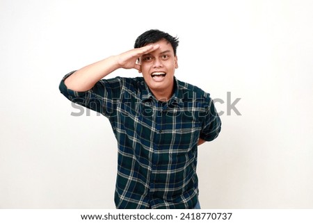 Young asian man, hand and search in distance, future and looking ahead isolated on white. College student with vision, goal and ambition with happy expression
