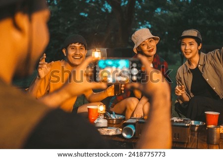 Group of asian people friend party camping in nature making toasting and taking photo by smartphone to share on social media. Hangout party outdoor in campsite nature on holiday weekend vacation