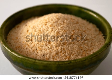 Close view of a green ceramic bowl filled with breadcrumbs Royalty-Free Stock Photo #2418776149