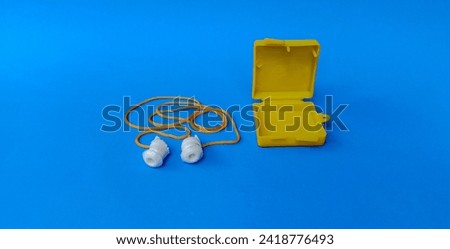 Ear plug to Reduce Noise Isolated on blue Background. Earplugs protect ears from noise.