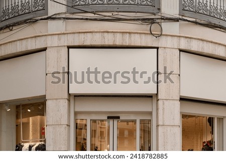 Storefront signage area with a blank space for a text or a logo, set above a shop window on a classic building facade. Signboard mockup.