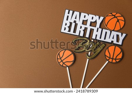 Happy birthday poster for boy on horizontal brown background with text and basketball symbol. Place the main object in the empty space on the left side of the image.
