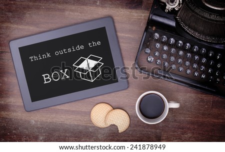 Tablet touch computer gadget on wooden table, think outside the box, vintage look