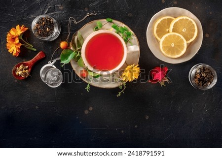 Tea with various ingredients and copy space. Herbs, fruits, and flowers, top shot on a black background. Healthy natural remedies