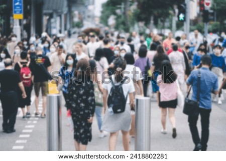 Blurred Crowd of unidentified people cross Orchard Road in Singapore. Royalty-Free Stock Photo #2418802281