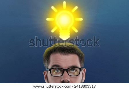 Idea generation. Man looking at illustration of glowing light bulb over him on dark blue background