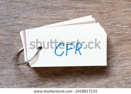 Flash card with handwriting in word CFR (abbreviation of Cost and freight) on wood background