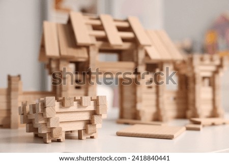 Wooden entry gate and building blocks on white table indoors, selective focus. Children's toy