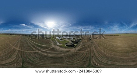 Spherical 360 degree panorama, aerial view: a huge dairy farm in the middle of endless fields near a small village in Europe. All the buildings of the cattle farm from an aerial view. Royalty-Free Stock Photo #2418845389