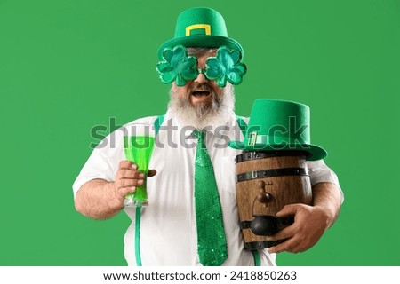 Mature man in hat with beer on green background. St. Patrick's Day celebration