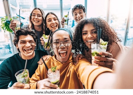 Multiracial friends drinking and toasting cocktail mojito at bar - Group of happy young people taking selfie picture at restaurant - Life style concept with youth guys enjoying happy hours