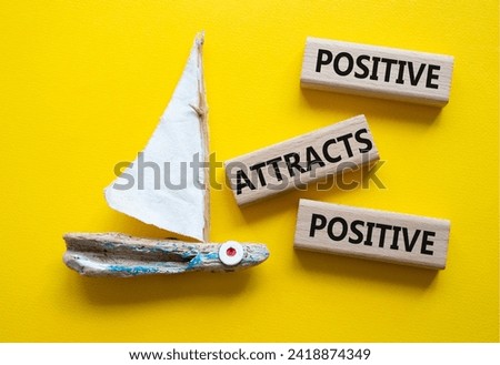 Positive attracts Positive symbol. Wooden blocks with words Positive attracts Positive. Beautiful yellow background with boat. Business concept. Copy space.