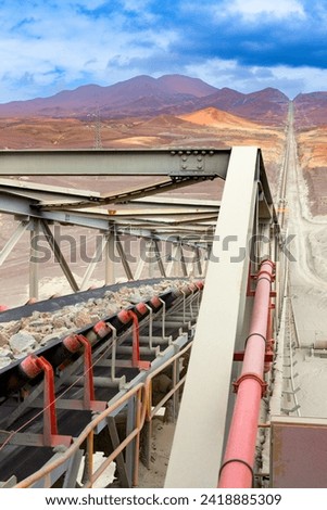 Raw mineral on a very large conveyor belt before being crushed at a copper mine in northern Chile.