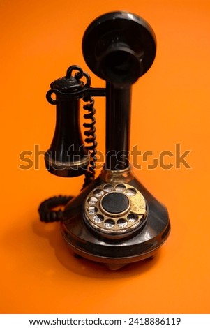 Vintage Rotary Dial Telephone on a Bright Orange Background Royalty-Free Stock Photo #2418886119