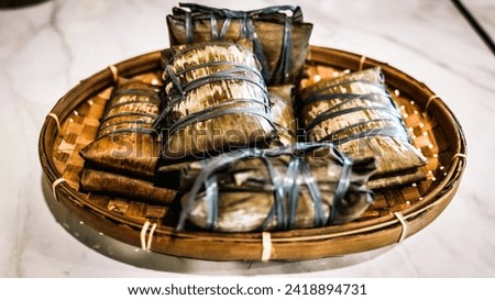 Rice wrapped in banana leaves and steamed is called buras. This is a typical food from Makassar, South Sulawesi. Can be served with Soto Makassar. Royalty-Free Stock Photo #2418894731