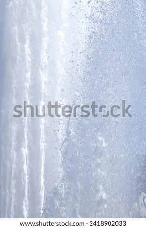 Fountain water streams dynamic motion. Wet spray summer waterfall background.