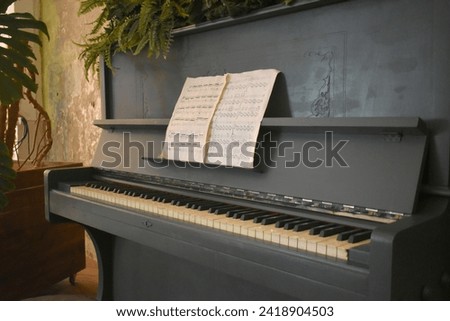 Piano background, notes, plants from behind. Acoustic instrument for playing music