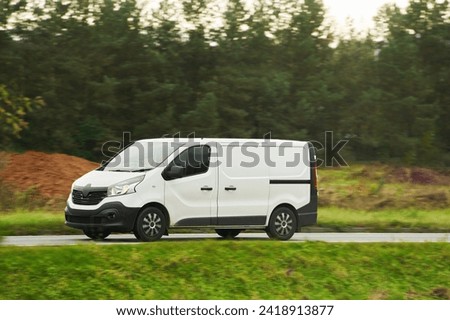 A white van with a blank wrap for your business branding and delivery service. Isolated mockup of a commercial vehicle on the road.
