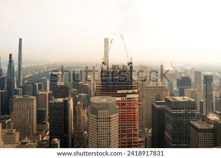 New York City, USA, a hazy polluted low mist engulfs the sky. Looking down on skyscrapers. New skyscraper is being built with Central Park in the background. No logos