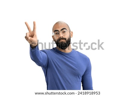 A man, on a white background, in close-up, shows a victory sign