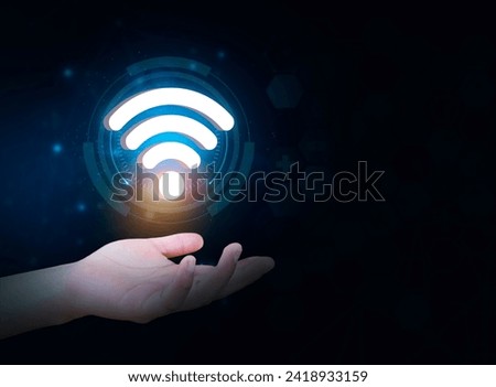 Person's hand holds a wifi symbol, isolated on dark background, Concept of connection at your fingertips. Access to the network, effective connection between humans