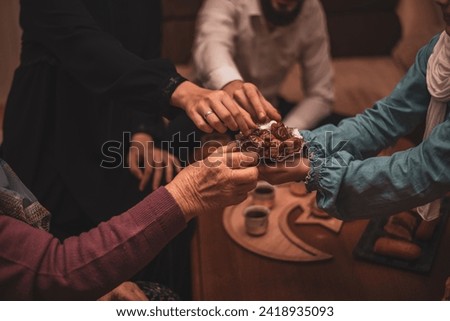 Happy Muslim family having iftar dinner to break fasting during Ramadan dining table at home. High quality photo Royalty-Free Stock Photo #2418935093