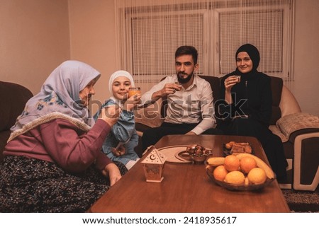 Happy Muslim family drinking Turkish coffee after dessert at home during the Eid Mubarak Ramadan. High quality photo Royalty-Free Stock Photo #2418935617