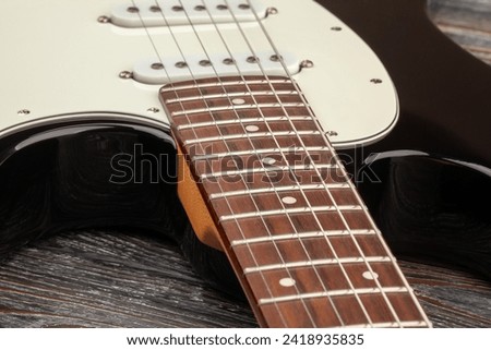 electric guitar fretboard body on wood background Royalty-Free Stock Photo #2418935835