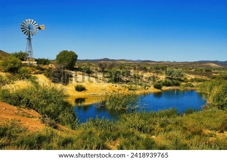 Oasis with windmill in the desert of the South Australian outback, in the Flinders Ranges in the vicinity of the village of Blinman
 Royalty-Free Stock Photo #2418939765