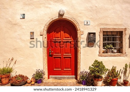 front view of, Fai della Paganella, Italy, stucco, house, front door and planters, on sunny day Royalty-Free Stock Photo #2418941329