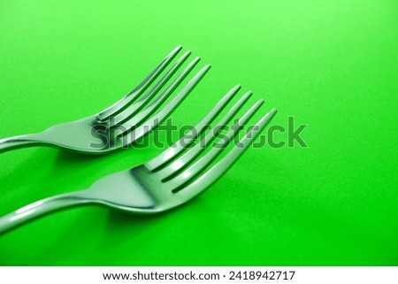 Fork's isolated on green mat background close up view, Food conceptual photography,    Metal Forks together macro photography 