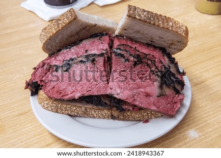 Pastrami sandwich at a Jewish deli restaurant in New York City. One of the iconic meats of American Jewish cuisine and New York City cuisine, hot pastrami is typically served at delicatessens Royalty-Free Stock Photo #2418943367