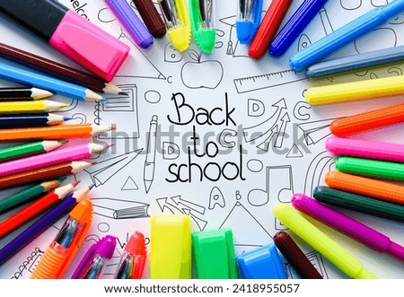 Back to school background on white paper with colored pencils, pens, markers and school office supplies