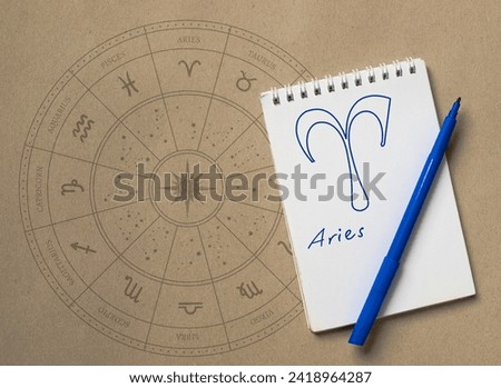 Notepad with pen and drawing of zodiac sign Aries Royalty-Free Stock Photo #2418964287