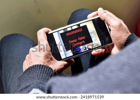Person got potential deep fake content message during watching a footage on his mobile phone. Selective focus Royalty-Free Stock Photo #2418971539