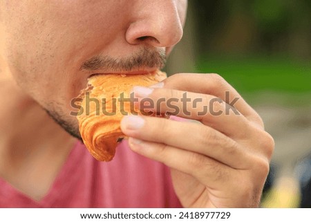Chewing mouth while eating, guy eats sesame bread. Background with selective focus and copy space for text