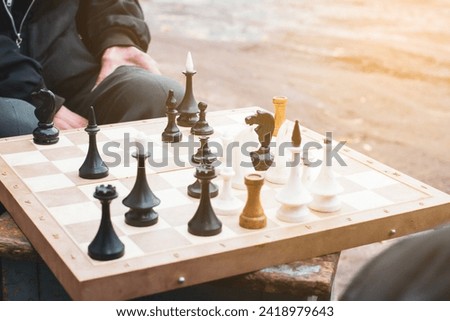 elderly people playing chess in the garage with nothing to do in their free time and talking about political topics with a cigarette