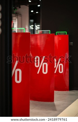 Scanner entrance gate for prevent theft in clothing store. The scanners are decorated with advertising posters informing about the sale with a discount.